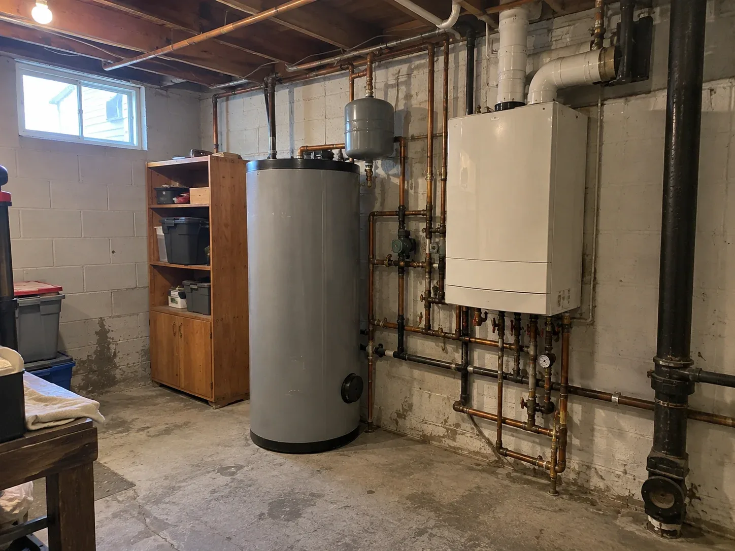 Wall-mounted heat-only boiler beside a separate indirect storage tank in a Hamilton home
